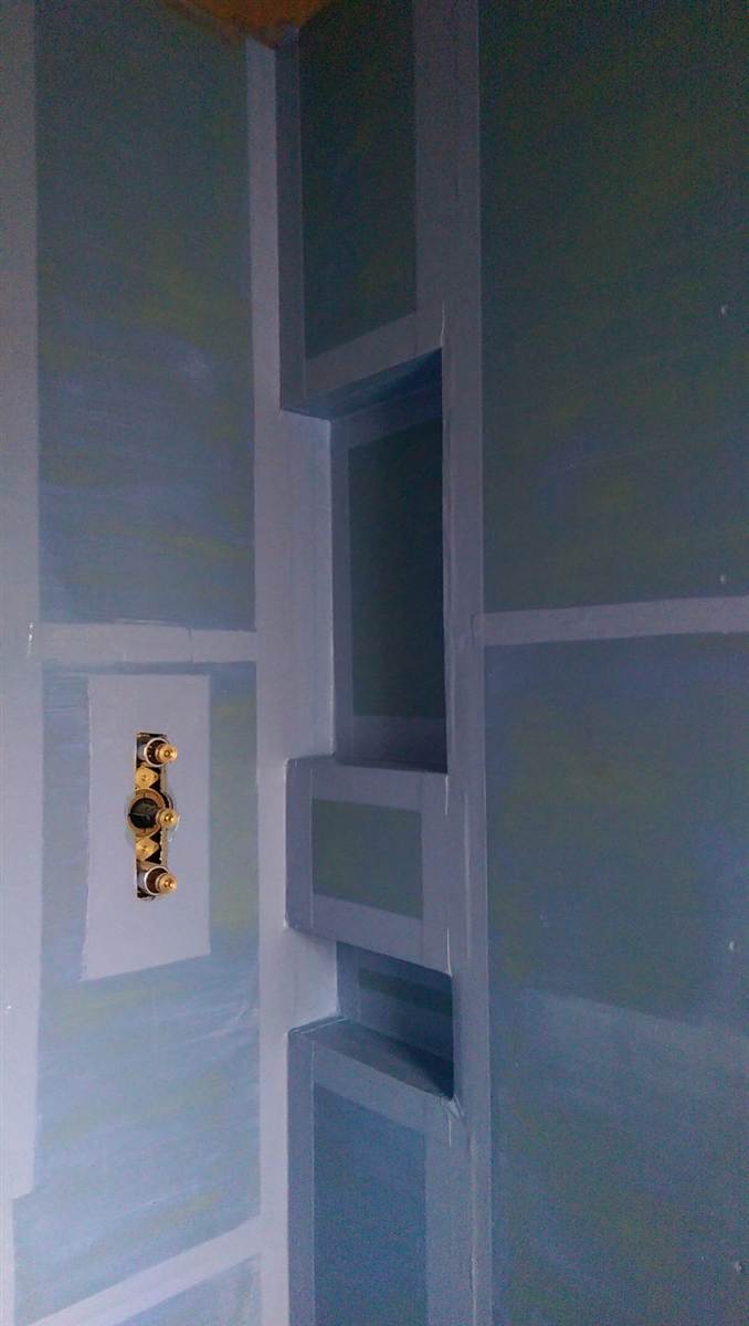 During — blue waterproofing membrane applied to shower walls with three recessed niches formed and tanked